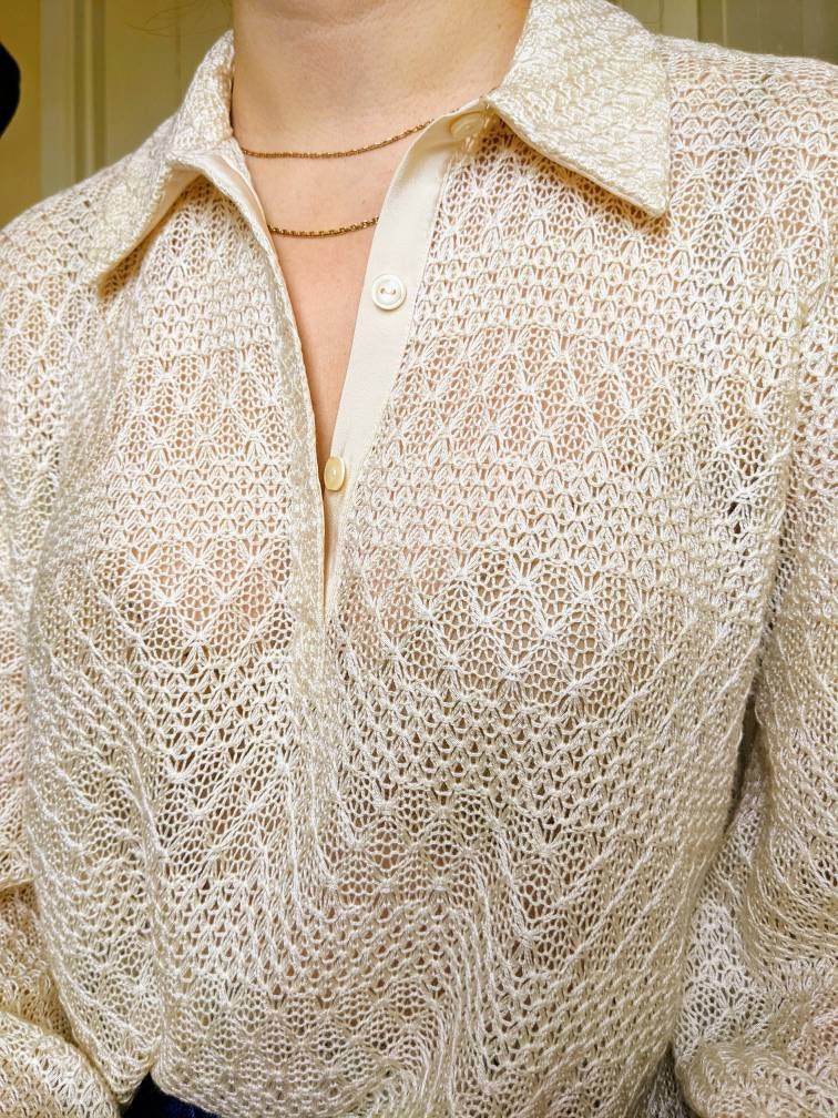 This closeup shows the fabric in more detail. The lace pattern creates horizontal stripes alternating between loose weave chevrons and a tighter decorative knit. The top is a little sheer and you can just see the model&#39;s bra through the fabric.